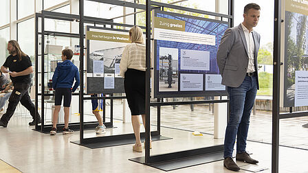 Foto wethouder Valstar die naar tentoonstelling kijkt. 