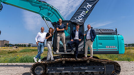 Wethouder Peter Valstar staat met eigenaren jed-id op een graafmachine. 